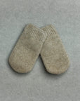 Pair of beige baby mittens on a gray background