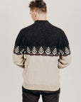 Man wearing a black and beige patterned sweater on a plain background