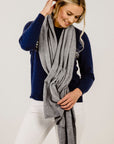 Woman wearing a gray scarf with a white background