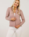 Woman wearing a pink zip-up sweater against a plain background