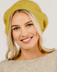 A woman wearing a yellow Merinosilk beret hat.