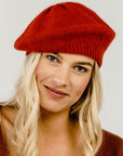 A woman wearing a red Merinosilk beret hat.