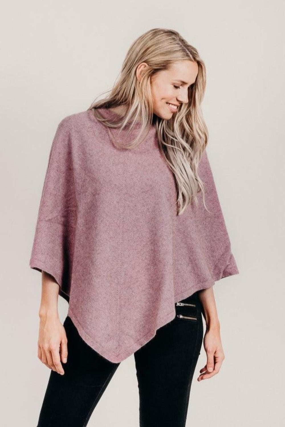 Woman wearing a petal poncho with black pants