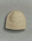Beige knit baby beanie on a gray background