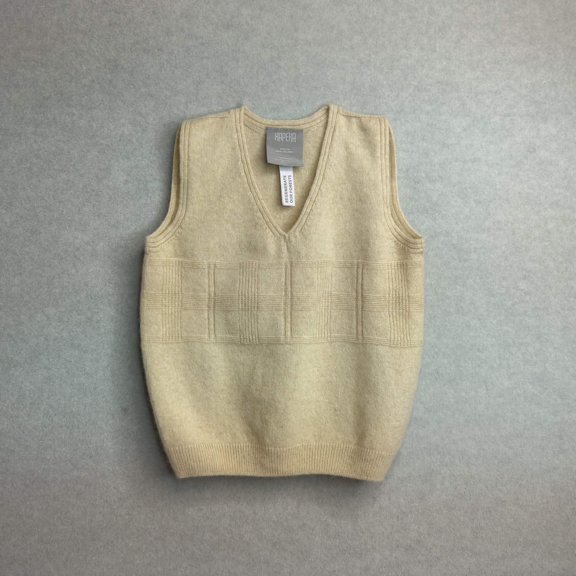 Beige baby sweater vest on a gray background