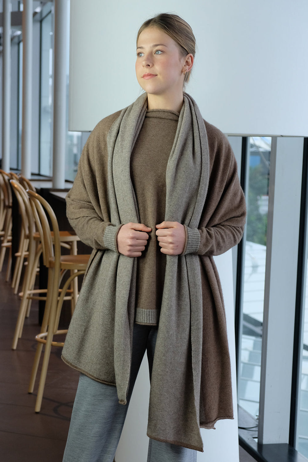 Woman wearing a long brown wrap  in an indoor setting
