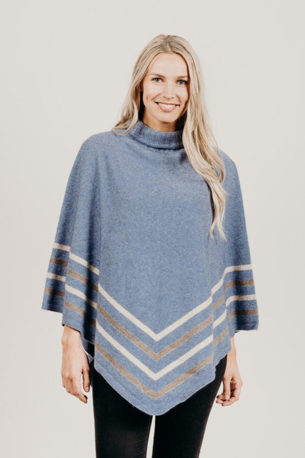 Woman wearing a ice Merinosilk Stripe Poncho with black pants