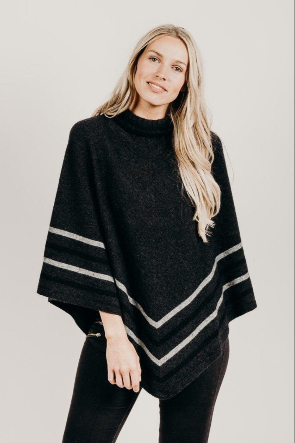 Woman wearing a charcoal Merinosilk Stripe Poncho  with black pants