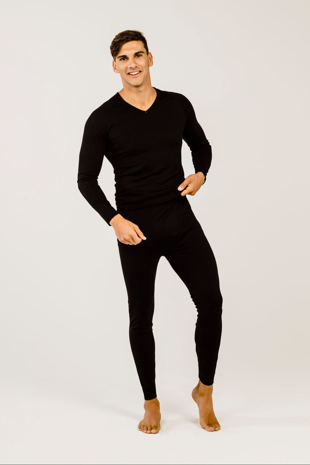 A man wearing a black long-sleeved merino wool V-neck sweater.